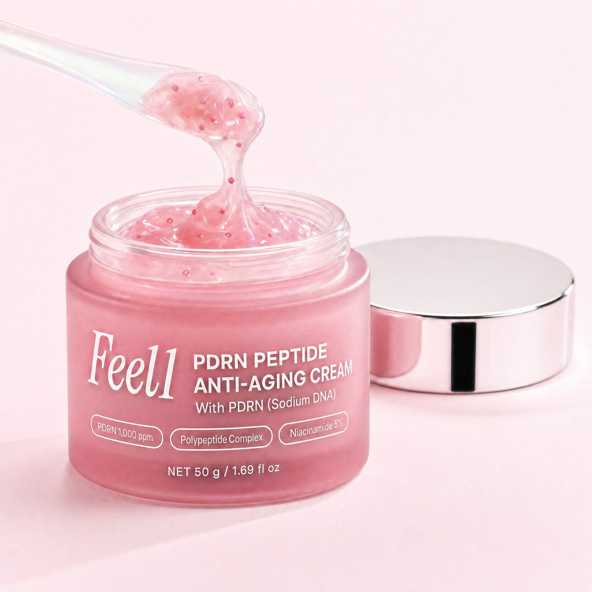 Pink gel cream texture with capsules on a spatula